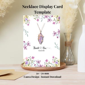 Puede incluir: Plantilla de tarjeta de exhibición de collar con diseño floral. La tarjeta presenta un collar con un colgante morado. El texto en la tarjeta dice "Thank You for your order". La tarjeta mide 5 x 7 cm.
