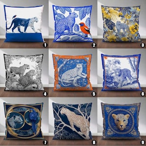 May include: Nine decorative throw pillows with leopard and floral designs. Pillows feature various color schemes, including blue, white, orange, and gold. Some pillows have a leopard print, while others showcase leopard illustrations with birds and foliage.