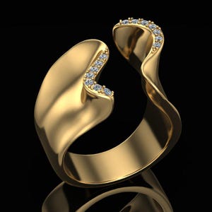 Könnte beinhalten: Ein goldener offener Ring mit einem glatten, gewellten Band und polierter Oberfläche. Eine Seite der Öffnung ist mit einer Reihe kleiner, klarer, rund geschliffener Steine besetzt, die entlang der geschwungenen Metallkante eingelassen sind.
