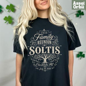 Peut inclure: Un t-shirt noir à manches courtes avec une impression graphique beige indiquant 2026 Family Reunion SOLTIS Clarklake, MI July 18, 2026. Le motif comprend des volutes décoratives et une illustration centrale d'arbre aux branches détaillées.