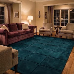 May include: A large, rectangular area rug in a deep teal color featuring a grid-like pattern of raised square tufts at the intersections of the lines. The rug is positioned on a hardwood floor in a living room setting with furniture.