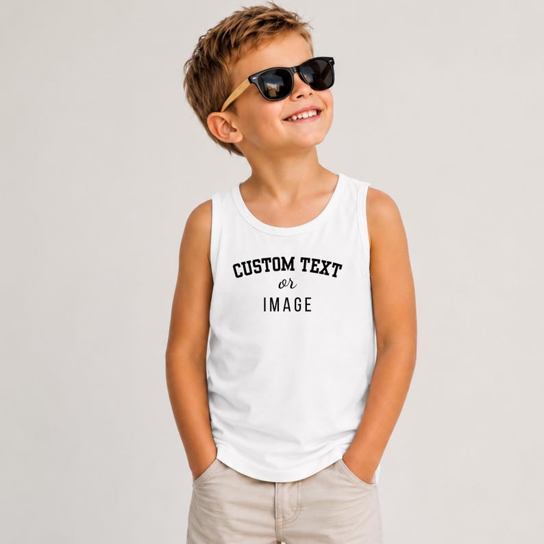 May include: A white sleeveless tank top featuring the black printed text CUSTOM TEXT or IMAGE centered on the chest. The garment has a round neckline and a standard fit, providing a clean and simple look for casual wear in various settings.