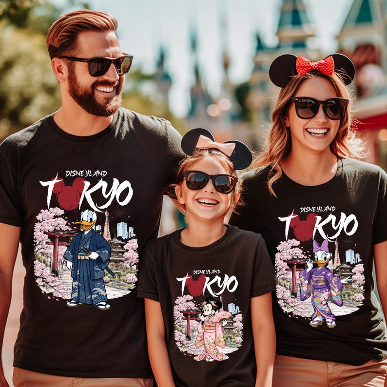 May include: Black t-shirts with a Disneyland Tokyo design. The shirts feature Donald Duck, Minnie Mouse, and Daisy Duck in traditional Japanese attire, with cherry blossoms and a pagoda. The text "Disneyland Tokyo" is displayed.