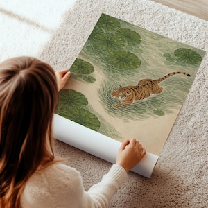 Puede incluir: Una impresi&oacute;n art&iacute;stica enrollada que representa un tigre nadando en un estanque con nen&uacute;fares. El tigre tiene rayas naranjas y negras. El agua y los nen&uacute;fares son verdes. La impresi&oacute;n est&aacute; sobre un fondo beige.