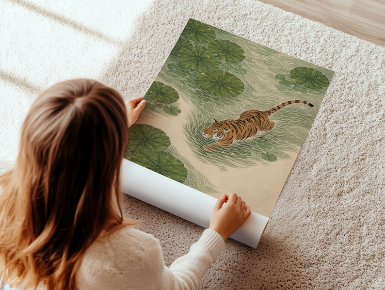 Puede incluir: Una impresi&oacute;n art&iacute;stica enrollada que representa un tigre nadando en un estanque con nen&uacute;fares. El tigre tiene rayas naranjas y negras. El agua y los nen&uacute;fares son verdes. La impresi&oacute;n est&aacute; sobre un fondo beige.