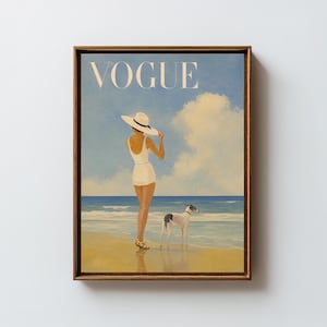 May include: A framed print of a vintage "Vogue" magazine cover. The artwork depicts a woman in a white swimsuit and hat on a beach with a dog. The background features a blue sky, clouds, and ocean.