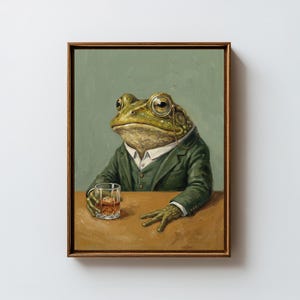 Peut inclure: Peinture encadrée d'une grenouille en costume vert, portant un monocle et tenant un verre de whisky. La grenouille est assise à une table marron sur un fond vert. L'œuvre a un style vintage et fantaisiste.