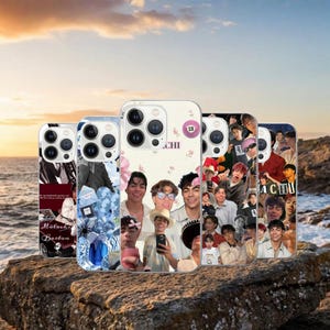 May include: A selection of phone cases with diverse designs. Some cases feature image collages, while others display floral patterns and text. The cases are mainly white and have a glossy finish, with camera cutouts.