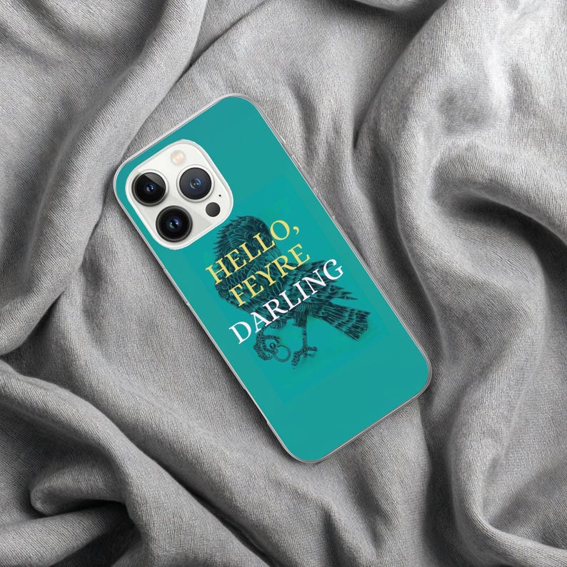 May include: Teal phone case with the text "Hello, Feyre Darling" and a detailed illustration of a bird. The case has a clear border and a camera cutout.