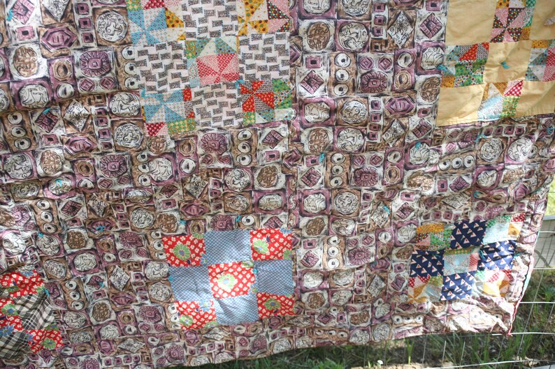 May include: A vintage patchwork quilt with a variety of patterned squares. The quilt features squares with repeating geometric and floral designs in shades of brown, pink, red, and blue. The quilt is hanging outside.