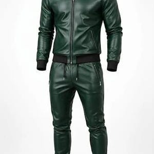 May include: A dark green leather tracksuit. The jacket has a zip-up front, a stand-up collar, and black ribbed cuffs and hem. The pants have a drawstring waist and zippered pockets, with black ribbed cuffs at the ankles.