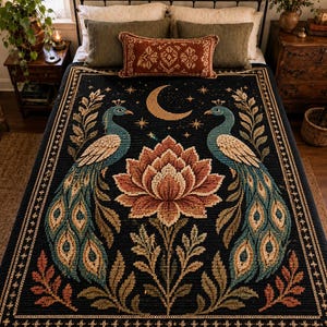 May include: A dark navy blue woven blanket featuring a central large lotus flower flanked by two symmetrical peacocks. Above the flower is a golden crescent moon surrounded by small stars. The border has a repeating geometric pattern.