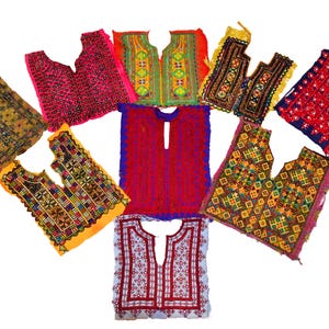 以下が含まれることがあります： 鮮やかな色の刺繍トップスコレクション。トップスは、赤、ピンク、緑、黄色、青の色合いで複雑な模様が特徴です。デザインには幾何学模様や花柄が含まれており、さまざまな文化的影響を示しています。