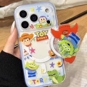 May include: Clear phone case with a Toy Story design featuring Woody, Buzz Lightyear, and other characters. The case has a pop-up grip with a rocket ship design. The text "Cute V Case" is at the bottom.