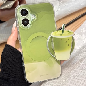 May include: A clear phone case with a green gradient design and a matching pop-up grip shaped like a matcha latte. The case has a clear border and a circular design on the back. The text "Jumpimoon" is visible.