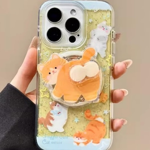 May include: Clear phone case with a glittery yellow background and multiple cartoon cat designs. The case features a large orange cat with a white belly and a smaller orange cat stretching. The text "Cute V Case" is visible.