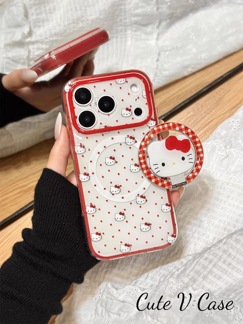May include: A clear phone case with a red border and a white background dotted with red spots and Hello Kitty faces. A matching phone ring holder is attached. The text "Cute V Case" is at the bottom.