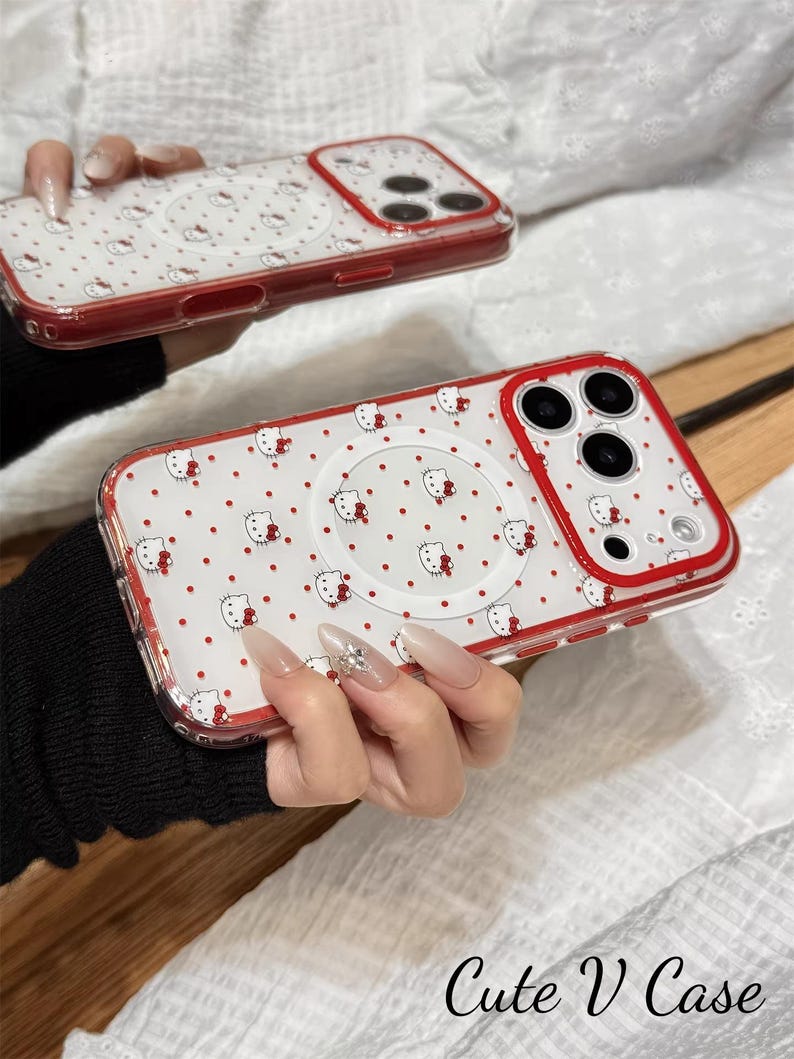 May include: Clear phone case with a red border, featuring a pattern of white Hello Kitty faces and red polka dots. The case has a circular design on the back and the text "Cute V Case".