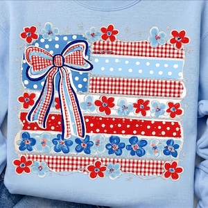 Può includere: Felpa azzurra con un design patriottico. Il design include un fiocco e strisce rosse, bianche e blu, con pois e motivi a quadretti. Il design è impreziosito da accenti floreali rossi e blu e glitter argentati.
