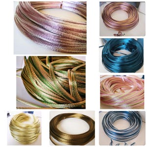 Puede incluir: Surtido de carretes de cinta decorativa en varios colores. Las cintas incluyen tonos de rosa, dorado, verde, azul y marrón. Las cintas están enrolladas en formas circulares, mostrando su textura y brillo.