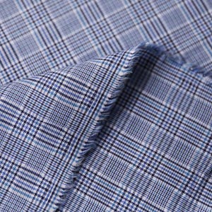 Könnte beinhalten: Nahaufnahme eines blau-weiß karierten Stoffes. Der Stoff hat ein klassisches Karomuster mit verschiedenen Blau- und Weißtönen. Die Kanten des Stoffes sind ausgefranst und zeigen die Textur und das Gewebe des Materials.