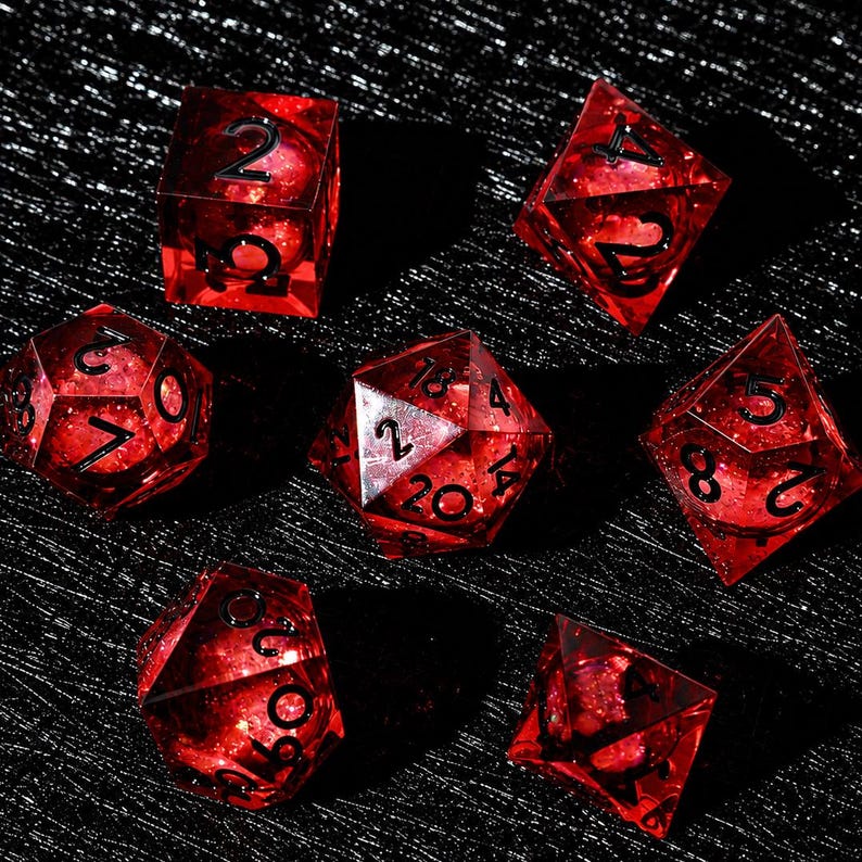 Peut inclure: Un ensemble de sept d&eacute;s poly&eacute;driques rouge translucide avec une num&eacute;rotation noire. Les d&eacute;s pr&eacute;sentent un int&eacute;rieur scintillant et paillet&eacute;, incluant un d20, d12, d10, d8, d6 et d4, affichant tous des chiffres noirs nets pour les jeux.