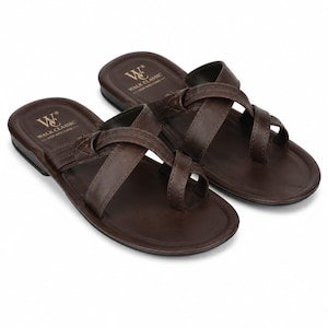 May include: A pair of dark brown sandals featuring a toe-post design and crisscross straps. The footbed is embossed with the text WALK CLASSIC STEP INTO CLASS and a logo. The sandals have a smooth finish and a simple, open-toe construction.