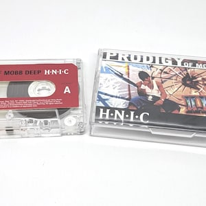 May include: A clear cassette tape and a cassette case. The cassette tape has a red label with the text "PRODIGY OF MOBB DEEP H-N-I-C". The cassette case has the same text on the cover, along with an image of a person.
