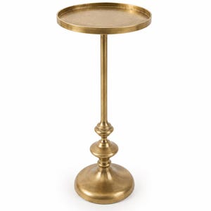 Puede incluir: Una mesa auxiliar alta y esbelta fabricada en metal de tono latón con una superficie circular plana y un borde elevado. La columna central de soporte presenta un diseño decorativo escalonado que se conecta a una base circular amplia y estable.