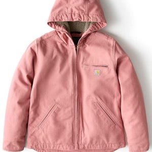 May include: A dusty rose-colored hooded jacket with a full zipper closure. The jacket features a small square logo on the chest and two front pockets. The hood has a soft, light-colored lining. A practical and stylish outerwear garment.