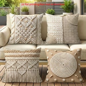 Könnte beinhalten: Vier quadratische Dekokissen in Beige- und Cremetönen mit 2D-Flachdruck, keine echte Stickerei. Die Designs umfassen Makramee-Muster mit Holzperlen, gewebte Seilspiralen, geflochtene Akzente und Fransen auf einem neutralen Stoff.