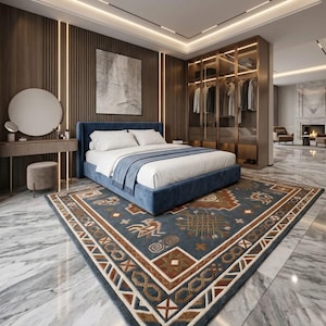 May include: A modern bedroom featuring a blue upholstered bed with white bedding and a patterned rug. The rug has a blue background with brown and cream geometric designs. A large closet and vanity are also visible.