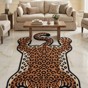 May include: A decorative leopard-shaped rug with a tan and black spotted pattern. The rug has a black border and a detailed face design. The rug is placed on a white tile floor in a living room setting.