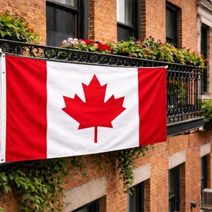 May include: A rectangular Canadian flag featuring a central white square with a red maple leaf emblem, flanked by two vertical red bands on the left and right sides. The flag is constructed with metal grommets at the corners for secure mounting.