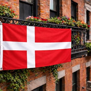 Könnte beinhalten: Eine rechteckige Flagge von Dänemark mit einem roten Feld und einem weißen nordischen Kreuz, das bis zu den Rändern reicht. Die Flagge ist horizontal ausgerichtet und zeigt einen weißen vertikalen Streifen und einen weißen horizontalen Streifen.