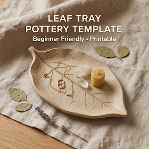May include: A beige leaf-shaped pottery tray with a gold necklace, crystals, and a small candle. The tray has the text "LEAF TRAY POTTERY TEMPLATE Beginner Friendly • Printable". The tray is on a beige linen cloth.