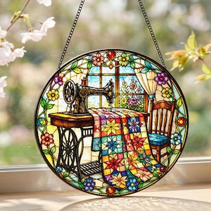 May include: A circular stained glass suncatcher featuring a vintage black sewing machine on a wooden table with a colourful star-patterned quilt draped over it, set before a window with a wooden chair and floral border accents in vibrant colours.