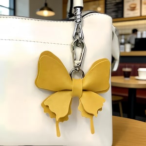 Llaveros de mariposa de cuero en varios colores, con broches dorados y detalles de alas caladas, accesorios colgantes para bolso de estilo bosque.