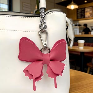 Leather butterfly keychains in multiple colors with gold clasps and cutout wing details, forest decor bag charm accessories.