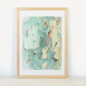 Peut inclure: Une peinture à l'aquarelle encadrée présentant une composition abstraite de formes organiques dans des tons de bleu sarcelle, vert sauge et crème. L'œuvre est insérée dans un cadre en bois clair avec un passe-partout blanc et une signature en bas.