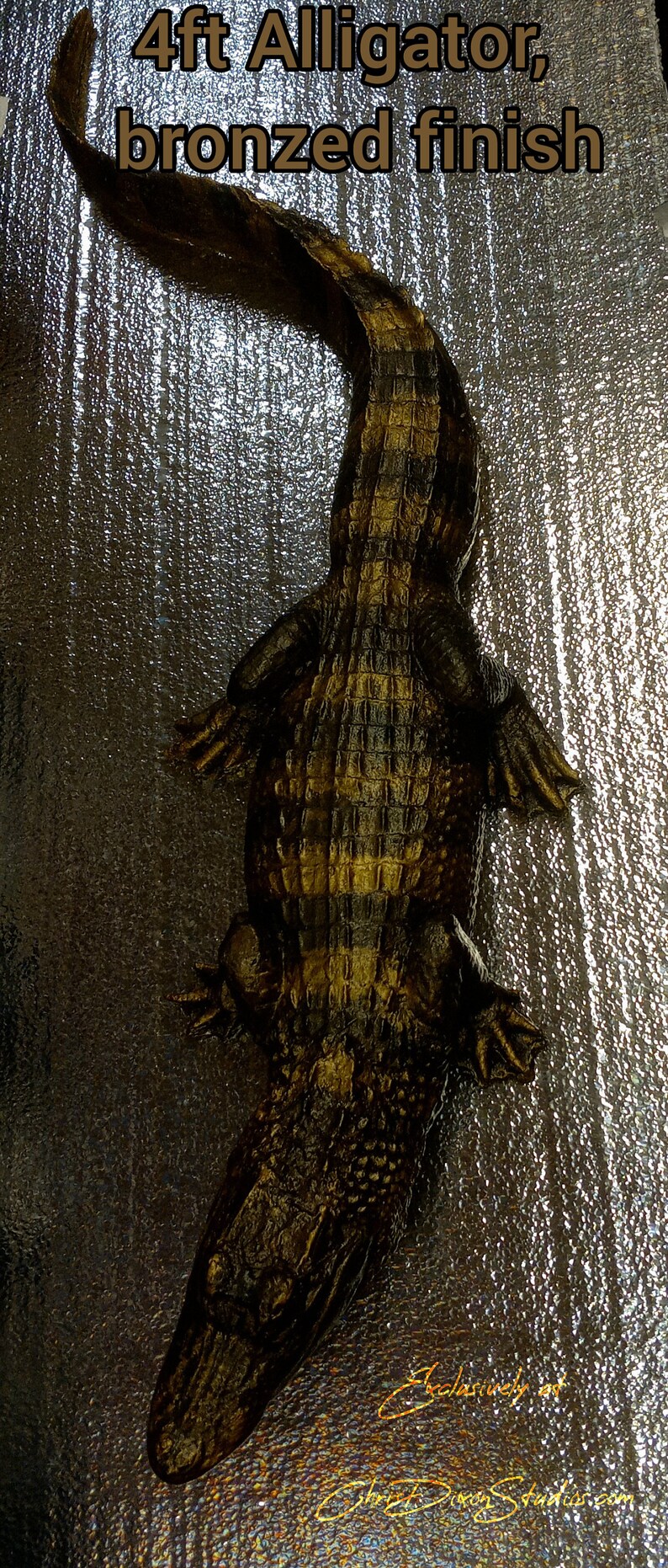 May include: A 4ft alligator sculpture with a bronzed finish. The alligator is posed with its head down and its tail curled up. The sculpture is made of a dark brown material and has a textured surface.