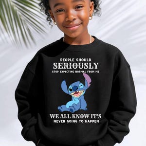 May include: A black long-sleeve sweatshirt featuring a graphic of the blue character Stitch from Lilo and Stitch. The text reads: PEOPLE SHOULD SERIOUSLY STOP EXPECTING NORMAL FROM ME WE ALL KNOW IT'S NEVER GOING TO HAPPEN in white lettering.