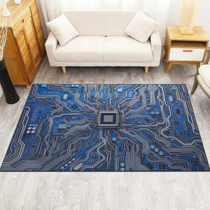 May include: A rectangular rug with a blue and grey circuit board design. The rug features a central square element and intricate lines resembling electronic pathways. The rug is placed on a light-coloured wooden floor.