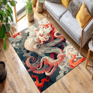 Op de afbeelding: Rechthoekig vloerkleed met een artistieke illustratie van een octopus met rode, witte en grijze details. De octopus staat tegen een donkerblauwe en grijze achtergrond met rode accenten. Het kleed ligt op een houten vloer.