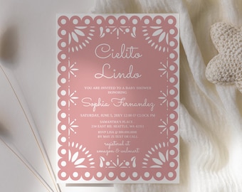 May include: Pink baby shower invitation with a white cut-out design. The invitation reads "Cielito Lindo" and "Sophia Fernandez". The invitation includes the date, time, and location of the baby shower. It also includes the RSVP information and registry details.
