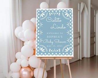 May include: A blue and white welcome sign with a decorative border. The sign reads "Cielito Lindo" and "Welcome to Sophia's Baby Shower" with the date "May 15, 20XY".