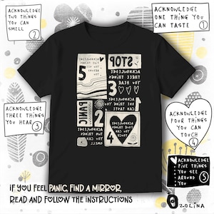Może przedstawiać: Czarny t-shirt z graficznym wzorem zawierającym instrukcje dotyczące radzenia sobie z paniką. Projekt zawiera ponumerowane kroki i komunikaty, takie jak „Zauważ dwie rzeczy, które możesz poczuć” oraz „Jeśli poczujesz panikę, znajdź lustro, przeczytaj i postępuj zgodnie z instrukcjami”.