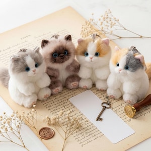 May include: Four plush toy kittens in different colours: grey and white, brown and white, orange and white, and grey and orange. Each kitten has blue eyes and a small loop for hanging. They are on a vintage paper background with a key and a wax seal.