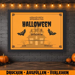 May include: A framed Halloween-themed sign with an orange background and black text that reads "S&uuml;&szlig;estes Halloween Kost&uuml;m". The sign features bats and a haunted house illustration. Pumpkins and candles decorate the scene.