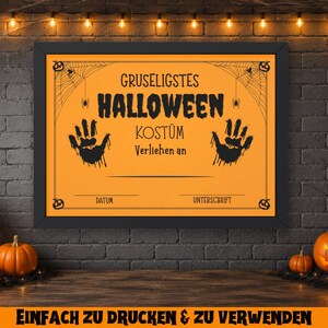 May include: A framed orange Halloween costume award certificate with black text and handprints. The certificate is decorated with spiderwebs and pumpkins. The background includes pumpkins, candles, and string lights.